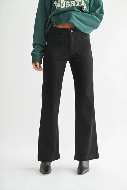 Black flare pants with patch pockets worn by a person, part of MINI PATCH POCKET FLARE JEANS collection