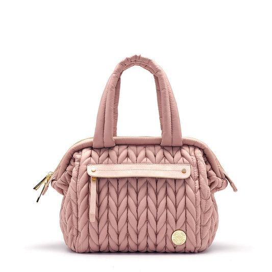 A dusty rose colored mini diaper bag with a structured frame and a 'Mary Poppins' style top opening.