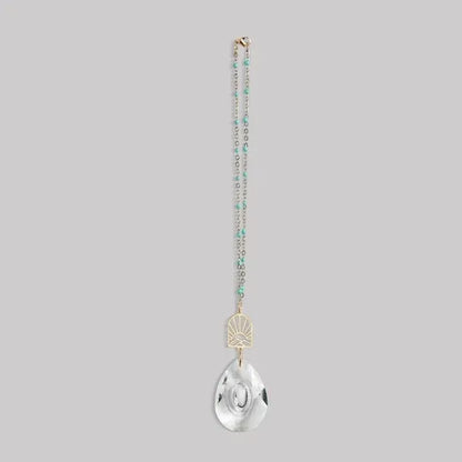 Delicate turquoise and gold pocket suncatcher necklace with clear teardrop pendant and sunburst design for women’s boho chic clothing