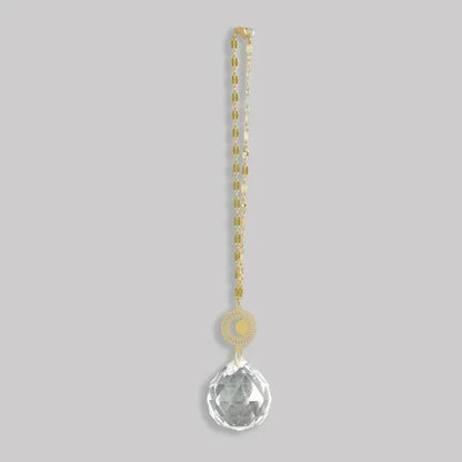 A clear faceted crystal pendant with gold-toned moon and sun charm on chain pocket suncatcher from shop daisy